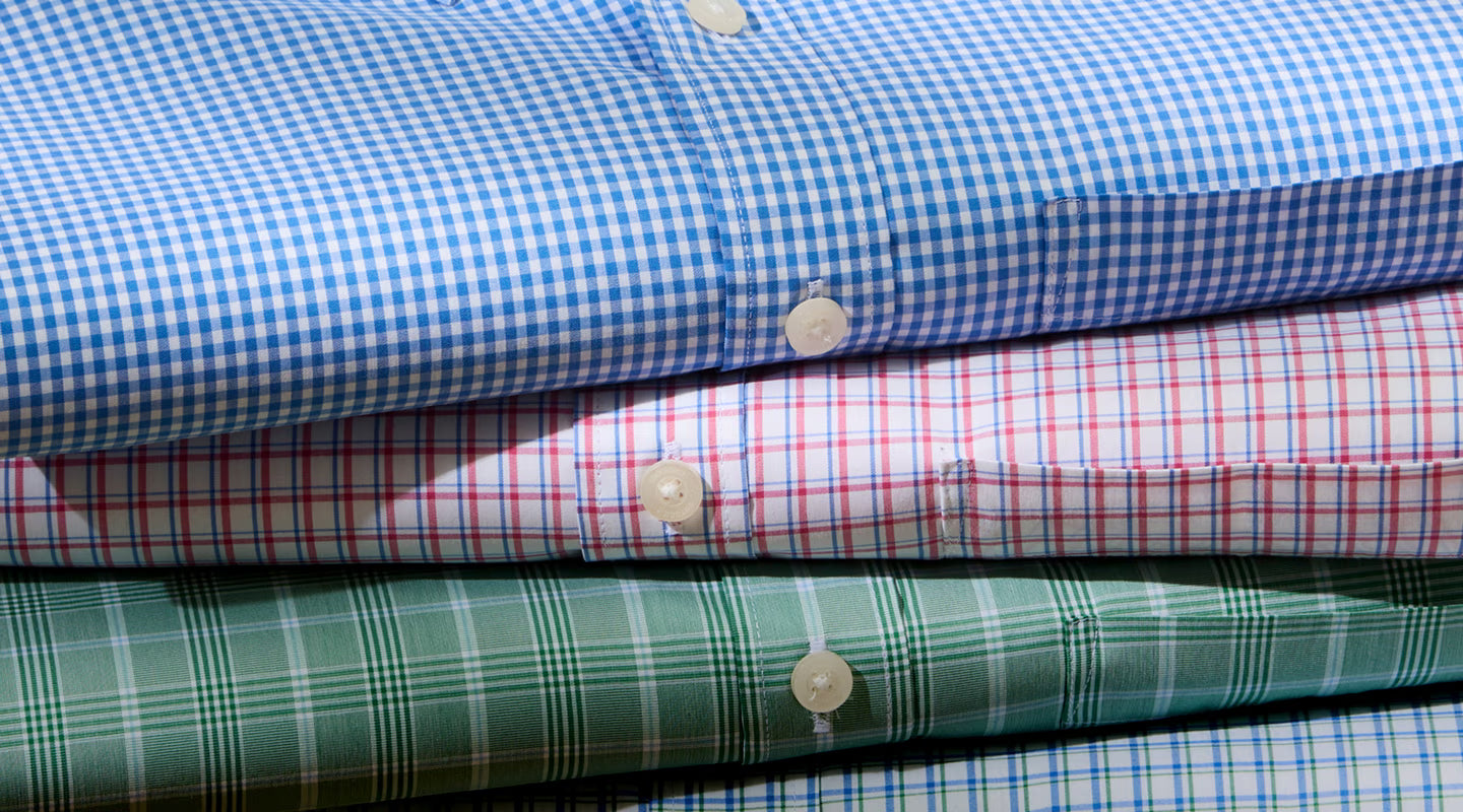 Stack of colorful checkered shirts in various patterns.